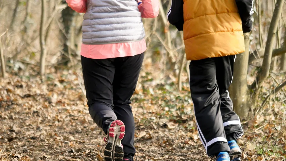 två personer springer i skogen